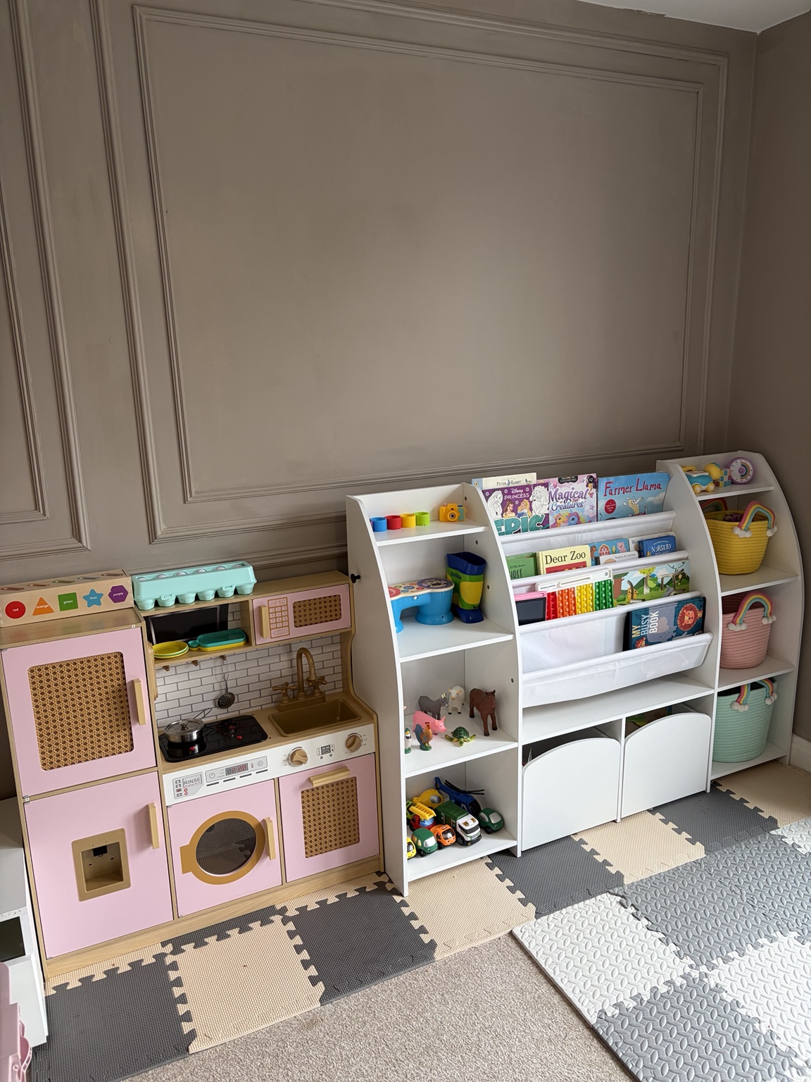 Colourful play kitchen and children's books in the childminding playroom